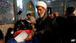 A cleric casts his ballot at a polling station in Tehran, Iran, March 1, 2024. The parliamentary and Assembly of Experts elections began with Iranian officials urging people to vote while others call for an election boycott.