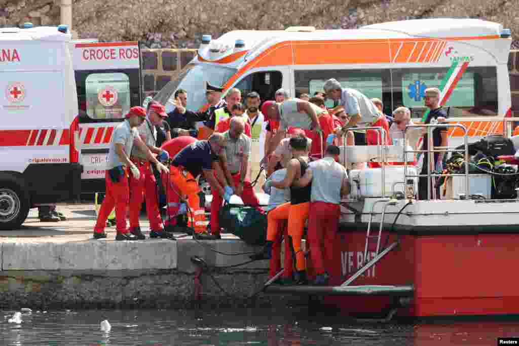 Emergency service members carry a body bag after a sailboat sank in the early hours of Monday, off the coast of Porticello, near the Sicilian city of Palermo, Italy.&nbsp;One man died and six people were missing, including British tech entrepreneur Mike Lynch, after a luxury yacht was struck by an unexpectedly violent storm and sank off Sicily.