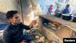 A Palestinian bakes bread using a clay oven, amid fuel and cooking gas shortages during the ongoing conflict between Israel and the Palestinian Islamist group Hamas, in Khan Younis in the southern Gaza Strip, Nov. 21, 2023.
