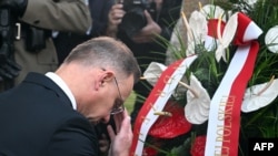 Poland's President Andrzej Duda makes the sign of the cross as he lays a wreath at the monument in memory of victims of the Nazi bombing on September 1, 1939, following the ceremony in Wielun, Sept. 1, 2024. 