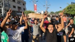 Palestinian demonstrators chant slogans during a protest against the territory's chronic power outages and difficult living conditions along the streets of Khan Younis, southern Gaza Strip, July 30, 2023.