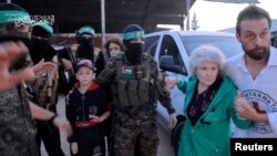Các con tin bị các tay súng Hamas bắt cóc trong cuộc tấn công vào Israel ngày 7 tháng 10 được bàn giao cho Hội Chữ thập đỏ Quốc tế, một phần của cuộc trao đổi con tin-tù nhân trong thời gian hưu chiến, ở Dải Gaza, ngày 24 tháng 11 năm 2023. (Hình ảnh do Hamas cung cấp)