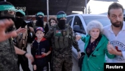 ໂຕ​ປະ​ກັນ​ທີ່​ຖືກ​ຈັບ​ໂຕ​ໄປ​ໂດຍ​ມື​ປືນກຸ່ມ​ຮາ​ມາ​ສ ໃນ​ການ​ໂຈມ​ຕີອິ​ສ​ຣາ​ແອ​ລ ​ເມື່ອ​ວັນ​ທີ 7 ຕຸ​ລາ​ຜ່ານ​ມາ ຖືກມອບ​ໃຫ້​ອົງ​ການ​ກາ​ແດງ​ສາ​ກົນ ອັນ​ເປັນ​ສ່ວນ​ນຶ່ງ​ໃນ​ການ​ແລກ​ປ່ຽນ​ນັກ​ໂທດ ທ່າມ​ກາງ​ການ​ຢຸດ​ຍິງ ໃນ​ເຂດ​ກາ​ຊາ ເມື່ອ​ວັນ​ທີ 24 ພະ​ຈິກ 2023. (Hamas handout/Reuters)