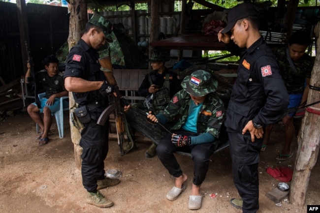 FILE - Members of the Karenni Nationalities Defense Force (KNDF) and Kareni Army (KA) are seen at a checkpoint near Demoso, in Myanmar's eastern Kayah state, Oct. 19, 2021.