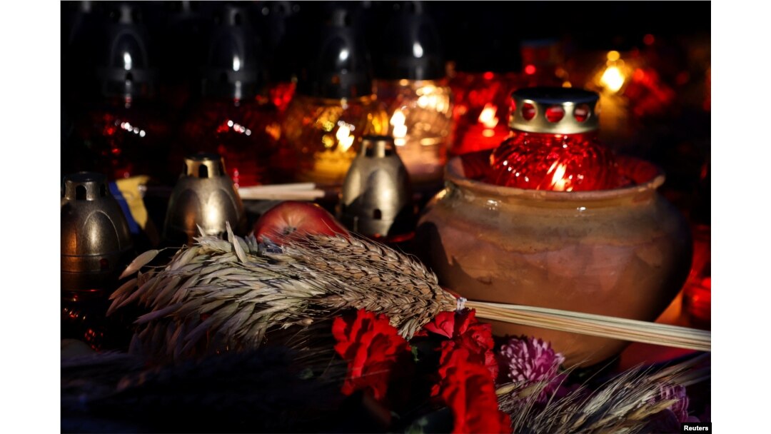 Lilin, bulir gandum, dan bunga terlihat di monumen korban Holodomor dalam upacara memperingati kelaparan tahun 1932-33, yang menyebabkan jutaan orang meninggal karena kelaparan, di Kyiv, Ukraina, 25 November 2023. (REUTERS/Sofiia Gatilova)