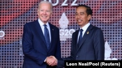 Presiden AS Joe Biden (Kiri) disambut Presiden Joko Widodo saat menjelang dimulainya KTT G20, 15 November 2022, Nusa Dua, Bali. (Foto: Leon Neal/Pool via REUTERS)