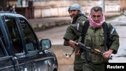 FILE - Christian fighters of Sutoro carry their weapons at a checkpoint in Tel Tamr, Syria, Feb. 25, 2015. Local reports said three members of Sutoro were killed in Turkish drone strikes on Derik, Syria, Feb. 28, 2024.
