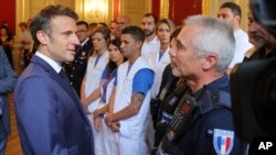 French President Emmanuel Macron, left, meets security and rescue forces in Annecy, French Alps, June 9, 2023 after a knife attack against young children.