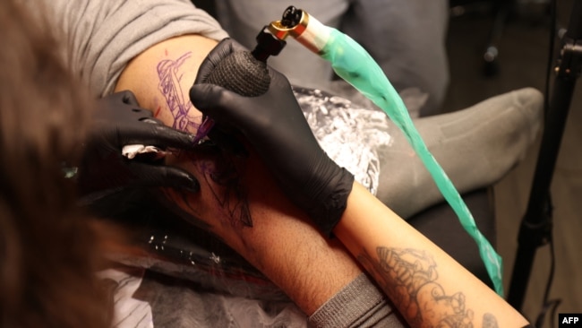 A tattoo artist traces a design on a customer at a tattoo studio in Tehran, Iran, on Nov. 7, 2023.