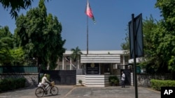 A cyclist pedals past the Afghan Embassy in New Delhi, India, Sept. 30, 2023. 