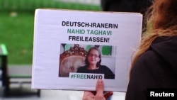 FILE - In a screen grab from video, a protester holds a sign demanding the German government do more for the release of German-Iranian national Nahid Taghavi, imprisoned in Iran, during a rally near the Chancellery in Berlin, Germany, Feb 22, 2023.