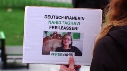 Potongan gambar dari sebuah video menunjukkan seorang demonstran memegang poster berisi tuntutan pembebasan warga Jerman keturunan Iran Nahid Taghavi, yang kini dipenjara di Iran, dalam sebuah aksi di Berlin, Jerman, pada 22 Februari 2023. (Foto: Reuters)