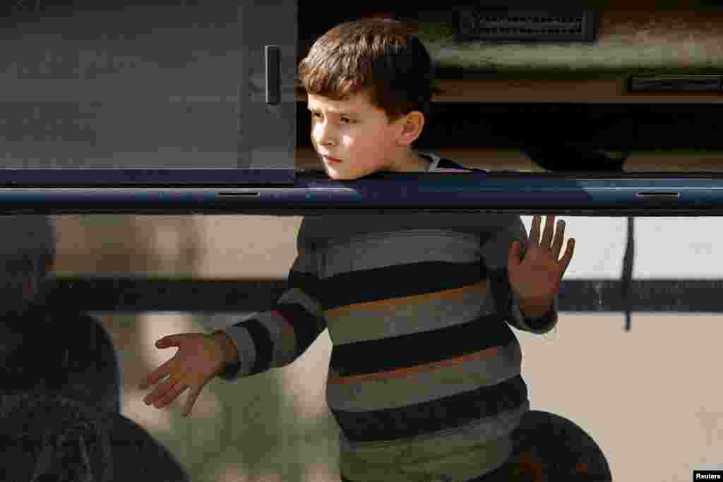 A boy looks out of a bus window as Palestinians wait for permission to leave Gaza, amid the ongoing conflict between Israel and Palestinian Islamist group Hamas, at the Rafah border crossing with Egypt.