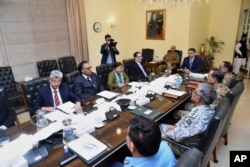 In this photo released by Pakistan's Prime Minister's office, caretaker Prime Minister Anwaar-ul-Haq Kakar, center right, chairs a meeting of the National Security Committee, in Islamabad, Pakistan, Jan. 19, 2024.