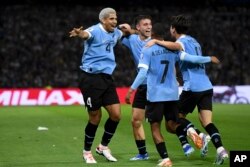 Ronald Araujo, 4, de Uruguay, celebra marcar el primer gol contra Argentina con sus compañeros durante un partido de fútbol de clasificación para la Copa Mundial de la FIFA 2026 en el estadio La Bombonera de Buenos Aires, Argentina, el jueves 16 de noviembre de 2023.