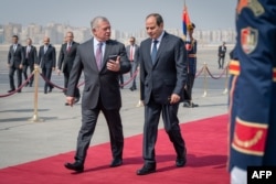 A handout picture released by the Jordanian Royal Palace shows Jordan's King Abdullah II (L) received by Egypt's President Abdel Fattah al-Sisi in Cairo, Oct. 19, 2023.