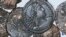 A picture made available by the Italian Culture Minister showing some of the discovered ancient bronze coins.