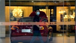 A worker walks in a Tesla showroom in Beijing, May 30, 2023.