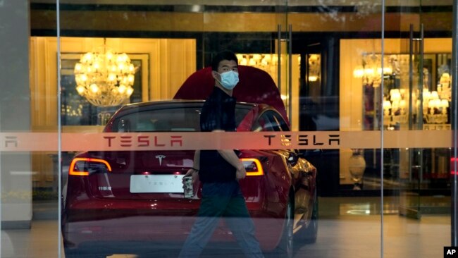 A worker walks in a Tesla showroom in Beijing, May 30, 2023.