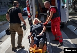 A medical worker treats a wounded resident at the site of a Russian missile strike, amid Russia's attack on Ukraine, in Kharkiv, Ukraine, Aug. 6, 2024