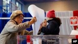 FILE - A woman casts her ballot during parliamentary elections in Warsaw, Poland, Oct. 15, 2023. Polish President Andrzej Duda will appoint a new prime minister in a national address on Monday.