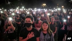 FILE - Demonstrators hold their cellphones aloft as they sing 'Glory to Hong Kong' during a rally at Chater Garden in Hong Kong on Oct. 26, 2019.