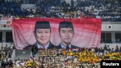 Sebuah spanduk raksasa pasangan capres-cawapres Prabowo Subianto dan Gibran Rakabuming Raka di antara para pendukung mereka di Jakarta, 25 Oktober 2023. (Antara Foto/Galih Pradipta/ via REUTERS)