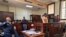 A police officer looks on as suspects stand in the dock during a court appearance in connection with an 18-year-old student who was allegedly kidnapped after engaging with someone on Grindr app, at the Johannesburg Magistrates Court in South Africa on November 15, 2023.