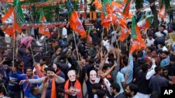 Supporters of India's ruling Bharatiya Janata Party, or BJP, celebrate early leads for the party in Rajasthan state elections in Jaipur, India, Dec.3, 2023.