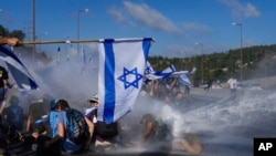 Poolisoonni Israa'eel mormitootatti bishaan facaasuudhan hiriira yeroo bittinneessan, Jerusaalem, Adoolessa 11, 2023. 