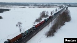 FILE - Trucks line up in a long queue to cross the Polish-Ukrainian border at the Dorohusk-Jagodzin crossing, in Brzezno, Poland, Dec. 4, 2023. 