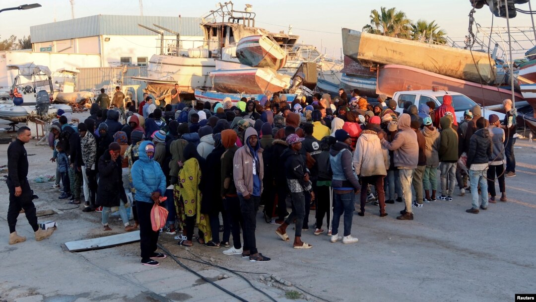 FILE - Migran menunggu di pelabuhan Sfax, setelah dihentikan oleh penjaga pantai Tunisia di laut saat mereka mencoba menyeberang ke Italia, 26 April 2023.