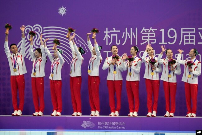 Gold medalist Team China celebrates on the podium during the victory ceremony for the team free routine artistic swimming at the 19th Asian Games in Hangzhou, China, Oct. 8, 2023.