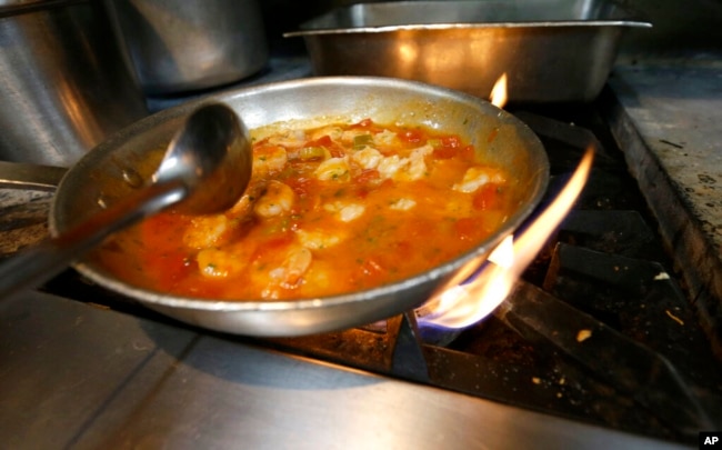 FILE - Shrimp creole is made at Antoine's Restaurant in New Orleans, in September of 2015. (AP Photo/Gerald Herbert)