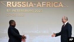 Mozambique President Filipe Nyusi, left, is greeted by Russian President Vladimir Putin during the official welcome ceremony for heads of delegations of countries taking part in the Russia Africa Summit in St. Petersburg, Russia, July 27, 2023.