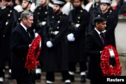 Britain's Prime Minister Rishi Sunak and Britain's main opposition Labour Party leader Keir Starmer carry poppy wreaths during the National Service of Remembrance at The Cenotaph on Whitehall in London, Nov. 12, 2023. (Henry Nicholls/Pool via Reuters)