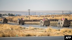 FILE - U.S. military vehicles patrol along a road near the town of Tal Baydar in Syria's northeastern Hasakeh province, Oct. 12, 2019. A one-way drone attack at Tal Baydar in Syria on Nov. 17, 2023, damaged infrastructure at the base and injured a service member.