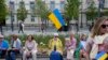 Люди з українськими прапорами у Вільнюсі в Литві, де станом на серпень 2023 р. зареєстровані понад 72 000 біженців від російської війни в Україні. Фото 11 липня 2023 р.