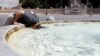 A person cools off at the Piazza del Popolo, during a heatwave across Italy, as temperatures are expected to rise further in the coming days, in Rome, Italy, July 18, 2023.