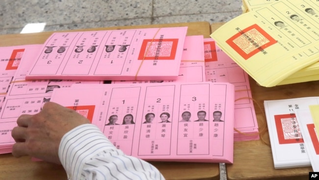 FILE - A staff sorts ballot papers at a polling station in Taipei, Taiwan, Jan. 13, 2024.