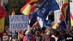 Para pengunjuk rasa memegang tanda '(Perdana Menteri) Pedro Sanchez pengkhianat' dalam aksi protes di alun-alun Puerta del Sol di Madrid, 12 November 2023. (Thomas COEX / AFP)