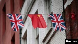 FILE - Chinese and British flags fly in London's Chinatown, Britain.