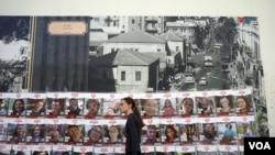 Una chica pasa junto a carteles con los rostros de los israelíes que permanecen aún en poder de Hamás.