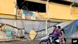 A motorcycle passes by a grocery store damaged by an earthquake in Bayugan City, southern Philippines, Dec. 3, 2023. An earthquake struck off the southern Philippine coast the night before.