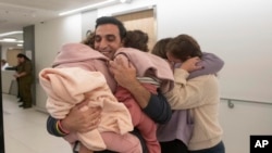 Aviv Asher, 2.5; her sister Raz Asher, 4.5, and mother Doron meet with Yoni, Doron's husband and their father, after they returned to Israel to the designated complex at the Schneider Children's Medical Center on Nov. 24, 2023. 