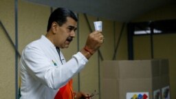Presiden Venezuela Nicolas Maduro menunjukkan surat suaranya dalam pemilihan referendum terkait status wilayah Esequiba, di tempat pemungutan suara di Caracas, Venezuela, pada 3 Desember 2023. (Foto: Reuters/Leonardo Fernandez Viloria)