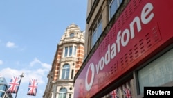 FILE - Branding is displayed for Vodafone at one of its stores in London, Britain, June 14, 2023.
