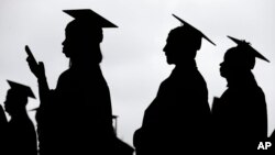 FILE - In this May 17, 2018, photo, new graduates line up before the start of the Bergen Community College commencement at MetLife Stadium in East Rutherford, NJ. 