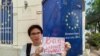2023年4月下旬，乔鑫鑫同友人一道在欧盟驻老挝外交机构门外举牌呼吁拆除网络防火墙。（乔鑫鑫提供照片）