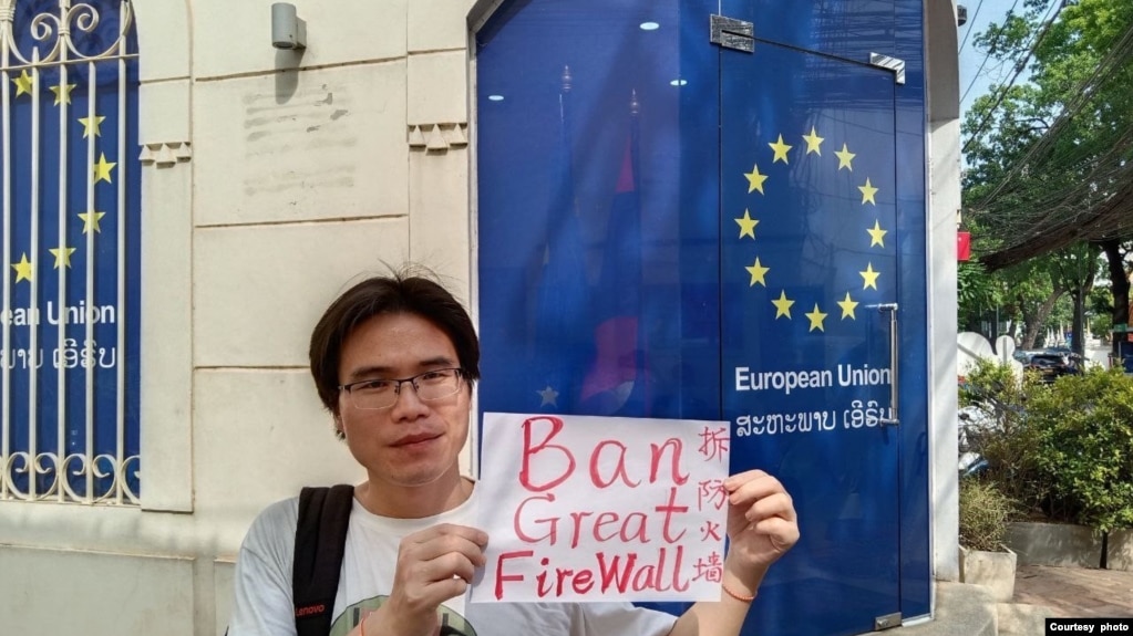 2023年4月下旬，乔鑫鑫同友人一道在欧盟驻老挝外交机构门外举牌呼吁拆除网络防火墙。（乔鑫鑫提供照片）